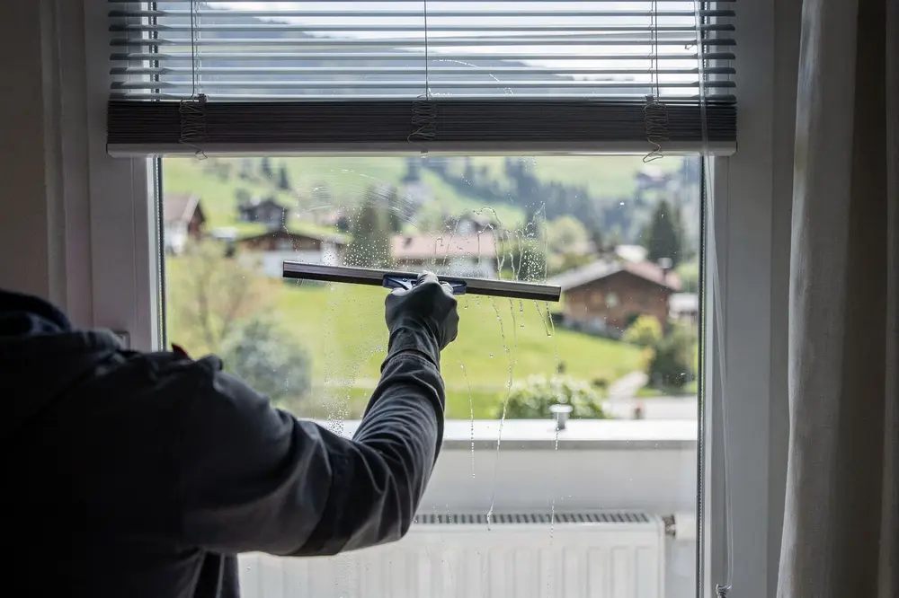 Symbolbild: Fensterreinigung mit Abzieher